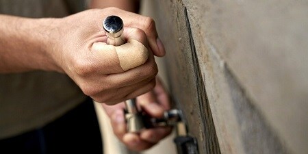 Ein Mann mit einem Pflaster am Finger führt Renovierungsarbeiten aus
