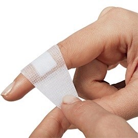 Eine Frau verbindet ihren Finger mit einem Pflaster